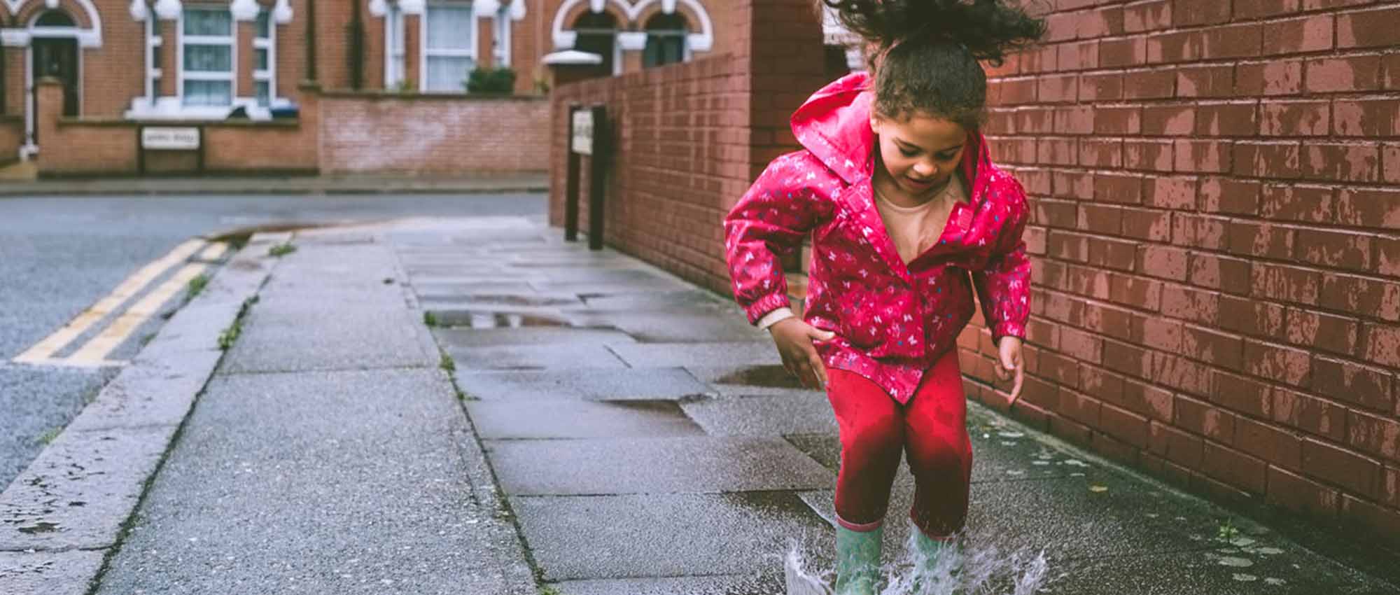 Girl jumping in puddle