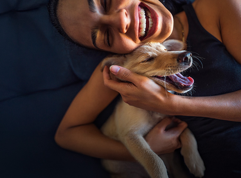 Woman hugging her dog smiling
