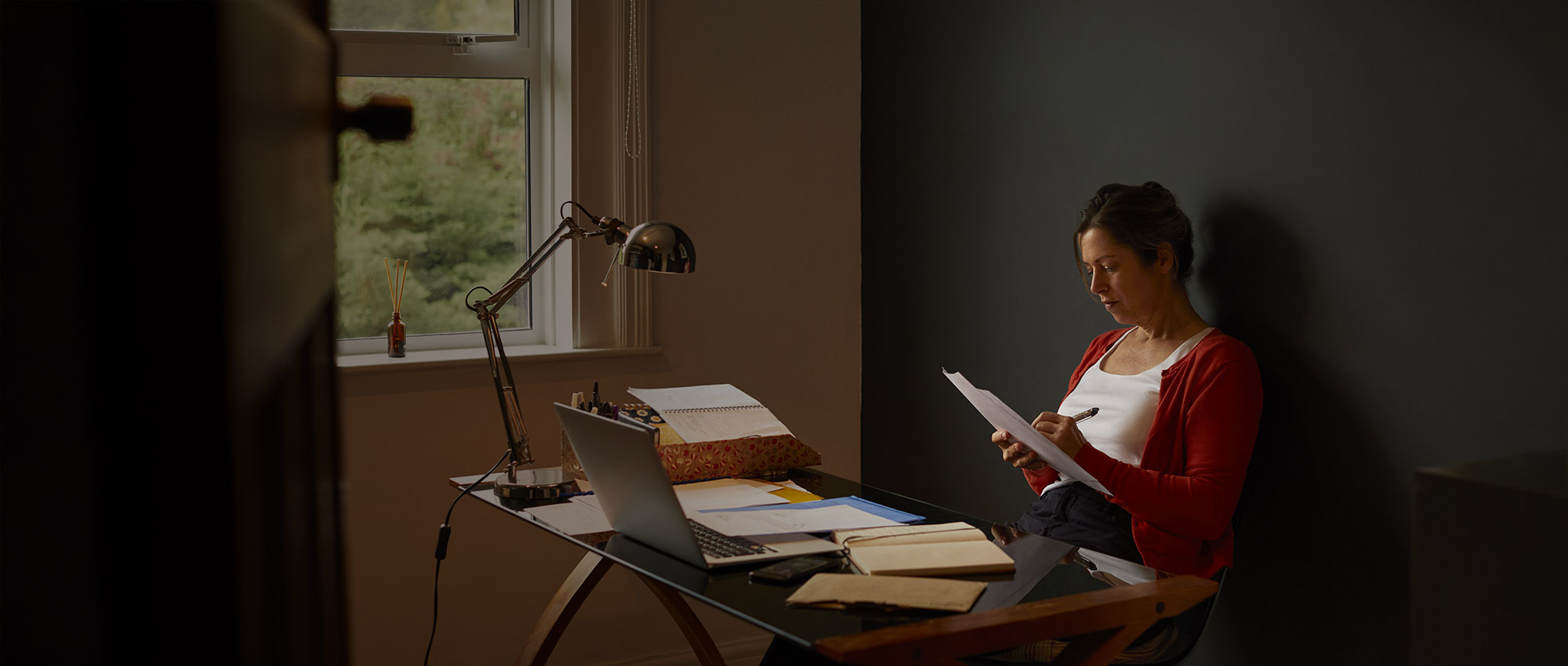 Woman sat at desk looking at paperwork