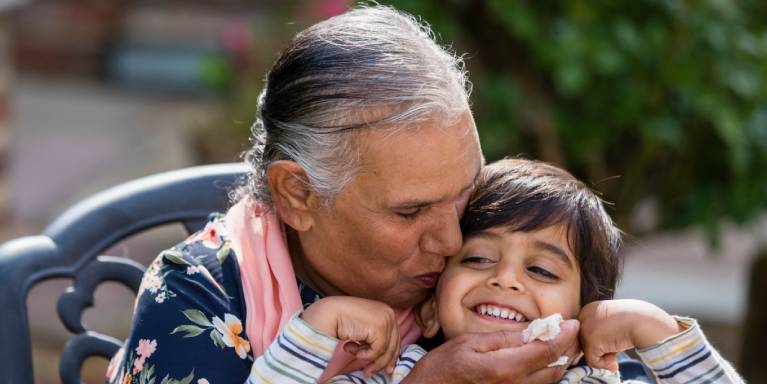 Grandparent kissing grandchild on cheek