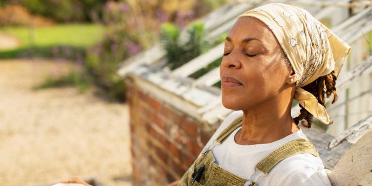 Woman sat on bench with eyes closed