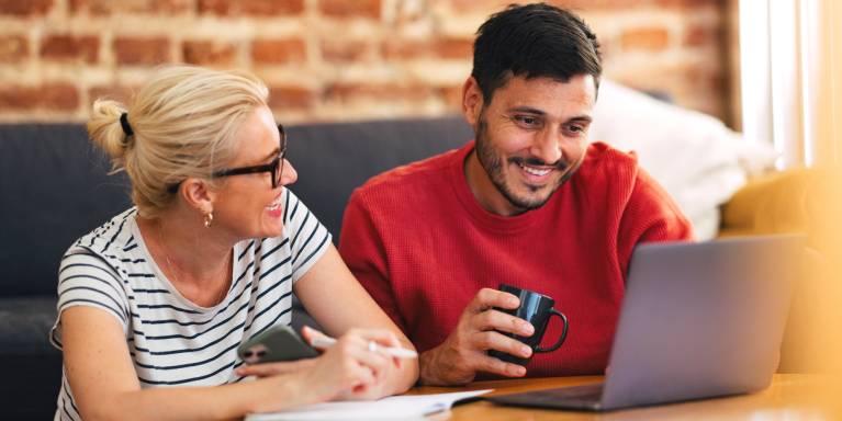 Man and woman using laptop smiling