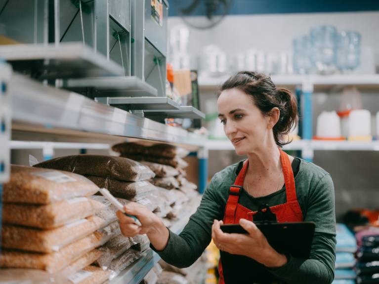 Woman working checking stock on shelves