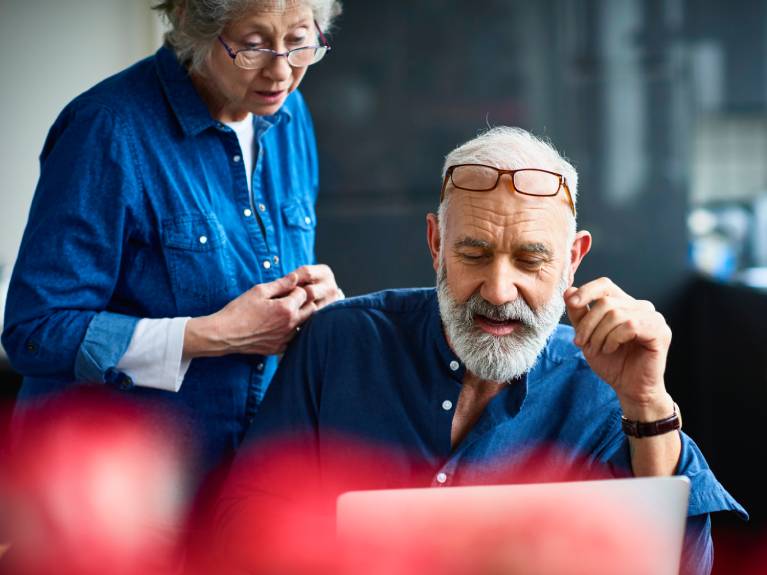 Older man and woman looking at laptop